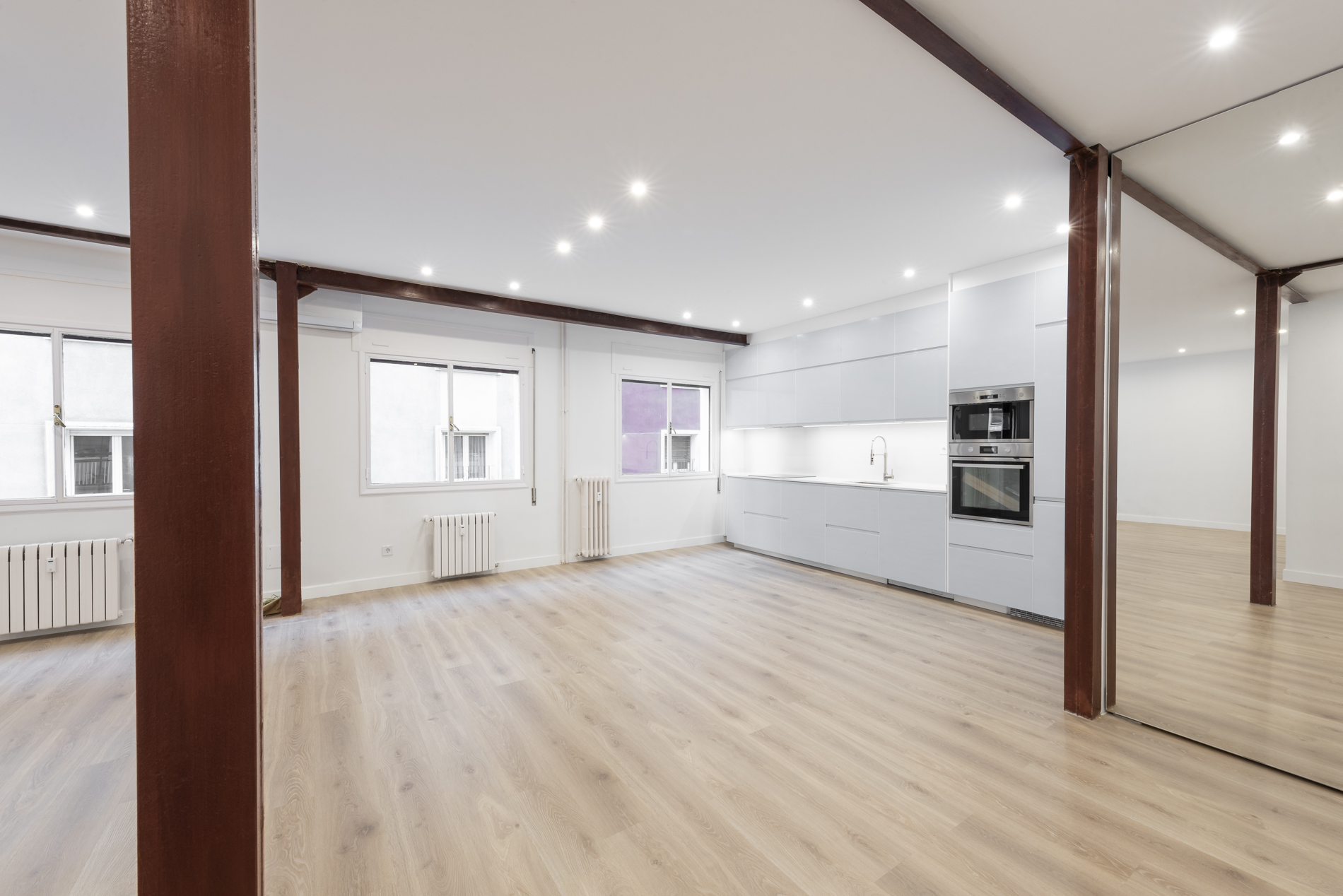 Cocina abierta al salón-comedor con vigas a la vista