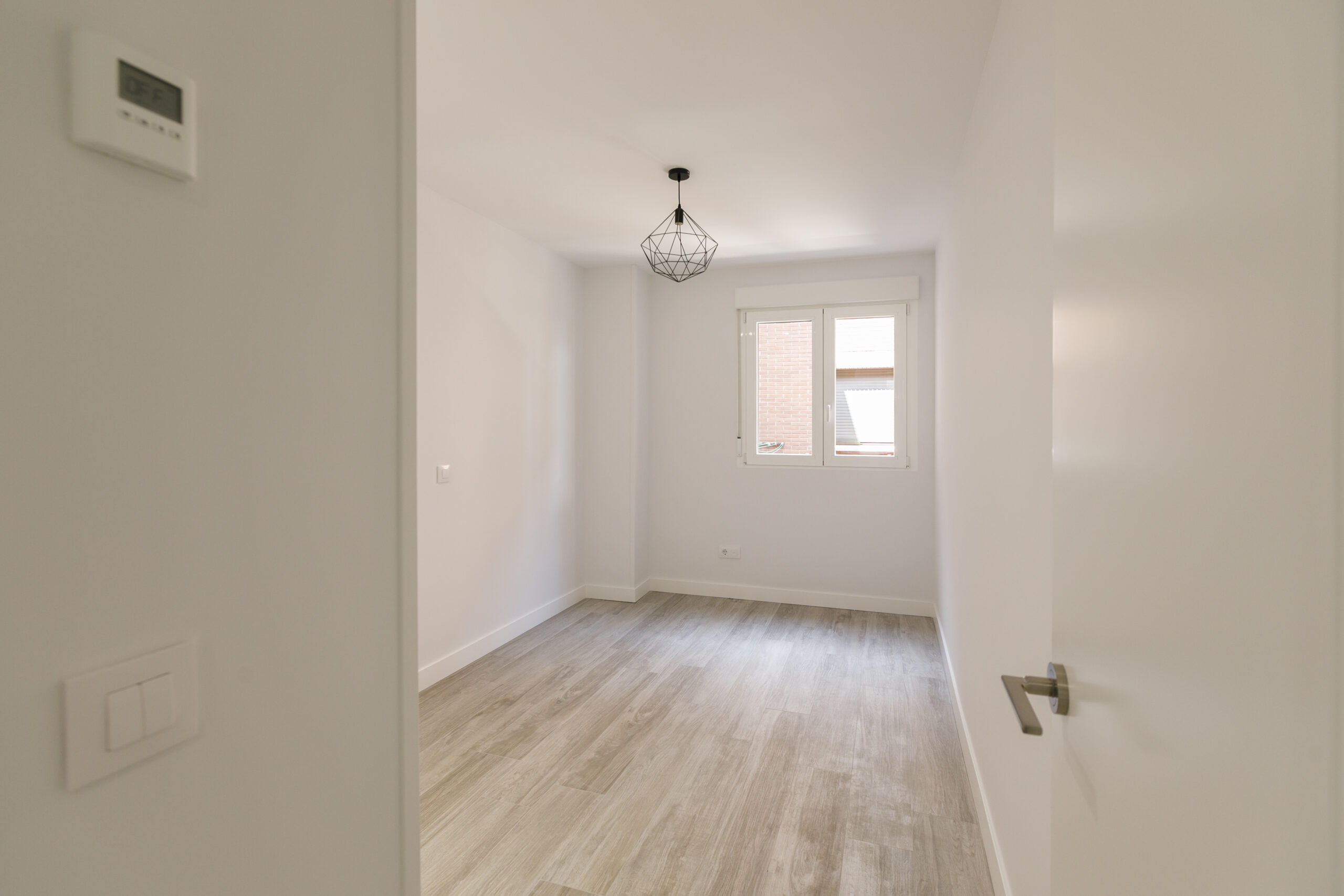 Habitación blanca con lámpara negra minimalista